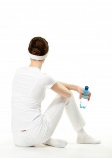 девушка в белом спортивном костюме с бутылкой воды