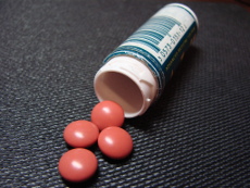 розовые таблетки четыре штуки на серой ткани